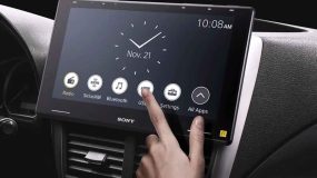 A person touching a button onscreen a sony car audio screen system